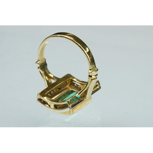 4 - Emerald and diamond unmarked yellow gold ring, the emerald cut emerald measuring approx 11mm x 7mm, ... 