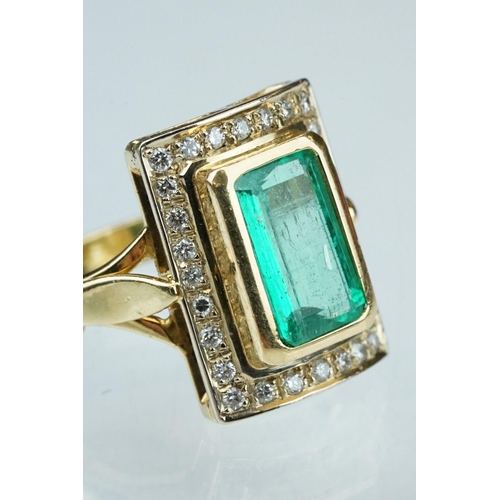 4 - Emerald and diamond unmarked yellow gold ring, the emerald cut emerald measuring approx 11mm x 7mm, ... 