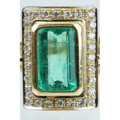 4 - Emerald and diamond unmarked yellow gold ring, the emerald cut emerald measuring approx 11mm x 7mm, ... 