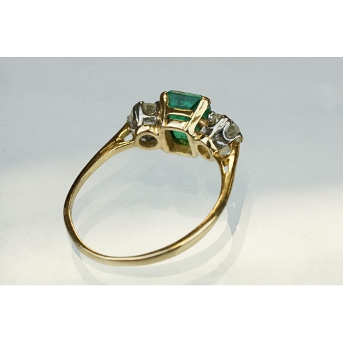 8 - Emerald and diamond 18ct yellow gold three stone ring,  the rectangular mixed cut emerald measuring ... 