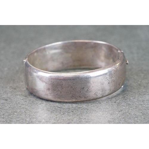 302A - Silver hinged bangle, engraved foliate scrolling decoration, tongue and box clasp, broken safety cha... 