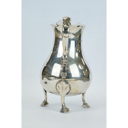 415 - Silver cream jug, the baluster body raised on three hoof feet, scroll handle, ogee rim, makers Jay, ... 