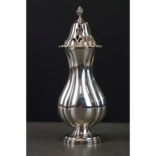 424 - Silver sugar caster, baluster form raised on scalloped oval foot, cast floral and foliate scroll bor... 