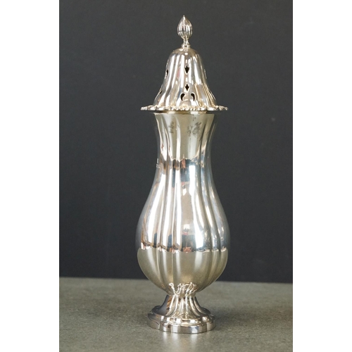 424 - Silver sugar caster, baluster form raised on scalloped oval foot, cast floral and foliate scroll bor... 