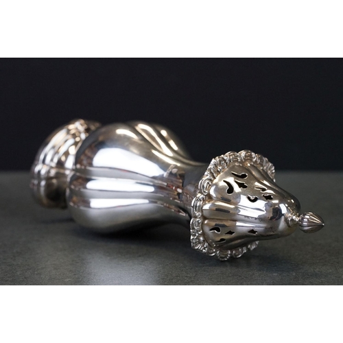 424 - Silver sugar caster, baluster form raised on scalloped oval foot, cast floral and foliate scroll bor... 