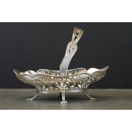 429 - Pair of silver swing handled bon bon dishes raised on four feet, pierced body, scalloped border, mak... 