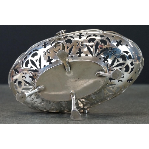 429 - Pair of silver swing handled bon bon dishes raised on four feet, pierced body, scalloped border, mak... 