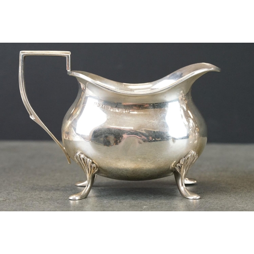 447 - Silver milk jug raised on four feet, angular handle, makers F H Adams & Co, Birmingham 1928, height ... 