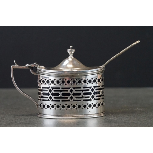 448 - Silver mustard pot and pepper pot, pierced form with geometric decoration, blue glass liners, makers... 