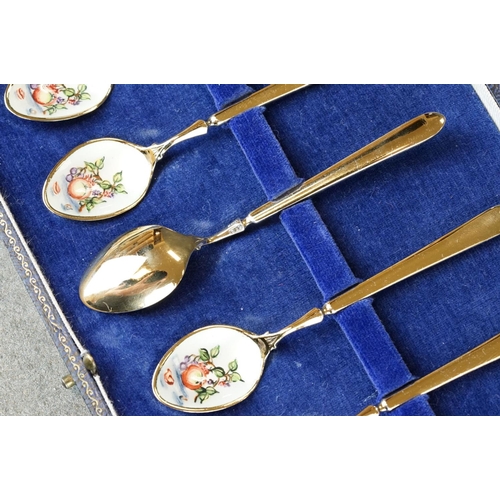 452 - Six enamelled silver gilt demitasse spoons, the bowls with white enamel decorated with fruit and lea... 