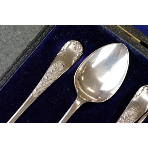 456 - Cased set of six Edwardian silver coffee spoons with matching sugar tongs, cast foliate decoration i... 