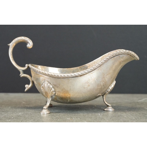 473 - Pair of silver sauce boats, gadroon border, scroll handle with cast acanthus leaf, three hoof feet w... 