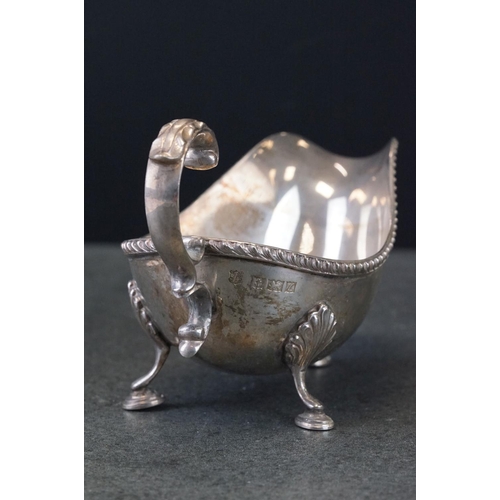 473 - Pair of silver sauce boats, gadroon border, scroll handle with cast acanthus leaf, three hoof feet w... 