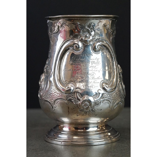 512 - Victorian silver tankard with embossed floral and scrolling decoration, with scrolling handle and pr... 