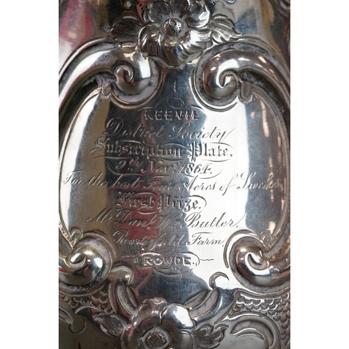 512 - Victorian silver tankard with embossed floral and scrolling decoration, with scrolling handle and pr... 