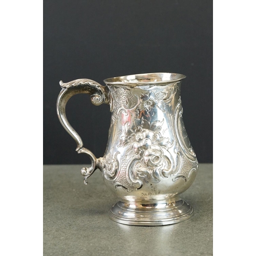 512 - Victorian silver tankard with embossed floral and scrolling decoration, with scrolling handle and pr... 