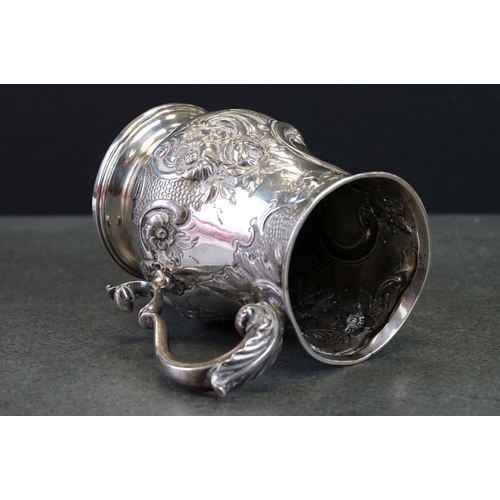 512 - Victorian silver tankard with embossed floral and scrolling decoration, with scrolling handle and pr... 