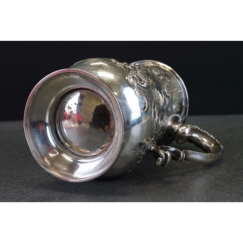 512 - Victorian silver tankard with embossed floral and scrolling decoration, with scrolling handle and pr... 