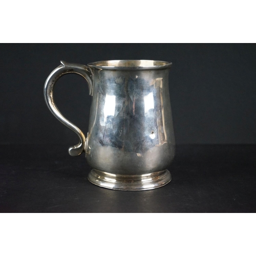 515 - George II silver tankard of plain polished form with moulded rim, foot rim and scrolling handle, mon... 