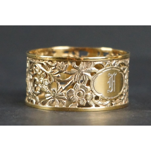 517 - Eight matching silver gilt napkin rings with pierced floral decoration, engraved monograms to cartou... 