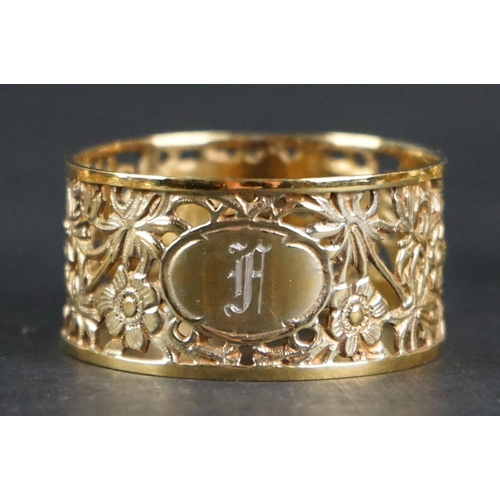 517 - Eight matching silver gilt napkin rings with pierced floral decoration, engraved monograms to cartou... 