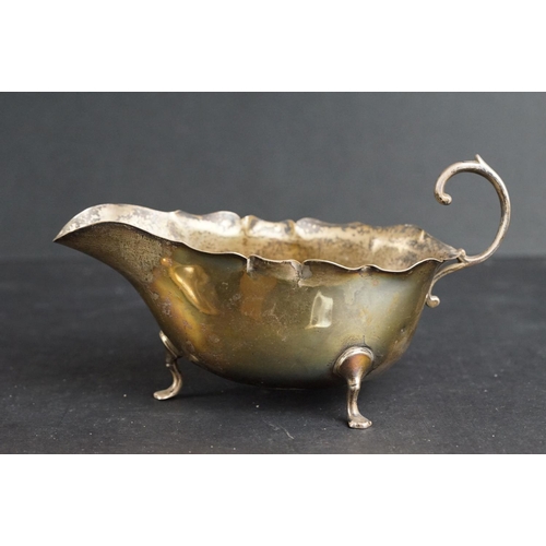 530 - Silver sauce boat, the plain polished body raised on three stylised feet, pie crust border, scroll h... 