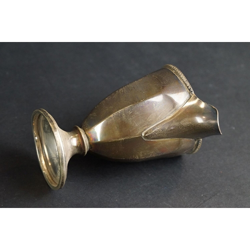 532 - Scottish silver milk jug, the faceted body raised on circular moulded foot, cast decoration to the r... 