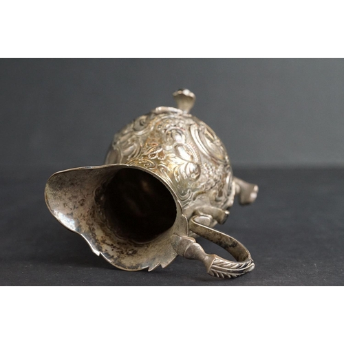 532 - Scottish silver milk jug, the faceted body raised on circular moulded foot, cast decoration to the r... 