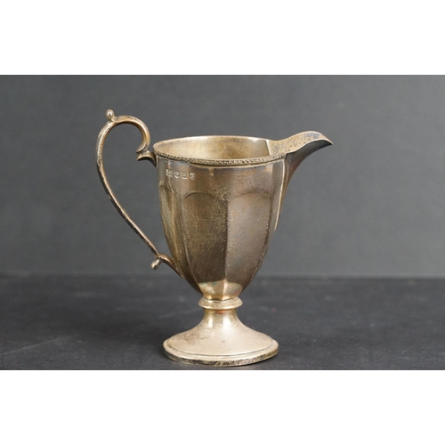 532 - Scottish silver milk jug, the faceted body raised on circular moulded foot, cast decoration to the r... 