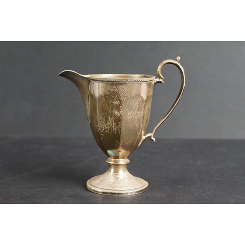 532 - Scottish silver milk jug, the faceted body raised on circular moulded foot, cast decoration to the r... 