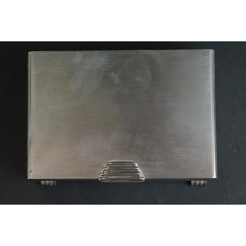 538 - Silver cigarette case, tapered ribbed thumbpiece to the hinged lid, engine turned decoration, the bo... 