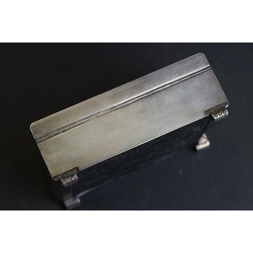 538 - Silver cigarette case, tapered ribbed thumbpiece to the hinged lid, engine turned decoration, the bo... 