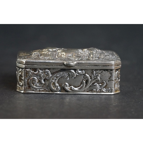 539 - Continental silver pill box, repoussé idyllic Shepherd and Shepherdess scene to the hinged lid, the ... 