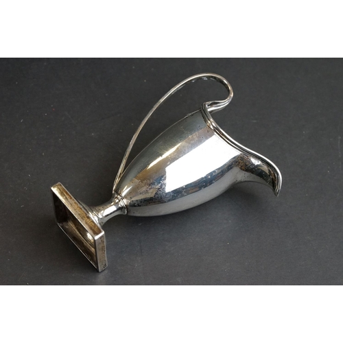 540 - Silver helmet shaped milk jug, the plain polished body raised on moulded circular foot to square ped... 