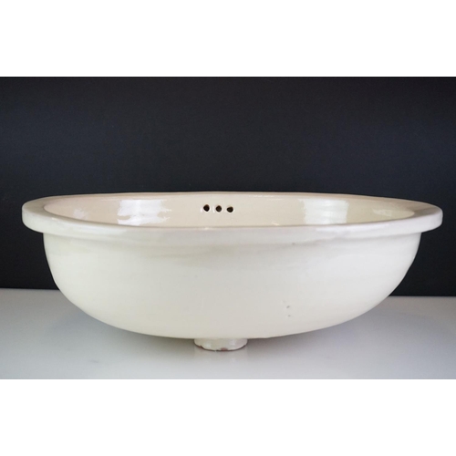 81 - Terracotta Mexican sink of oval form with floral decoration on a pale yellow ground, approx 50cm len... 