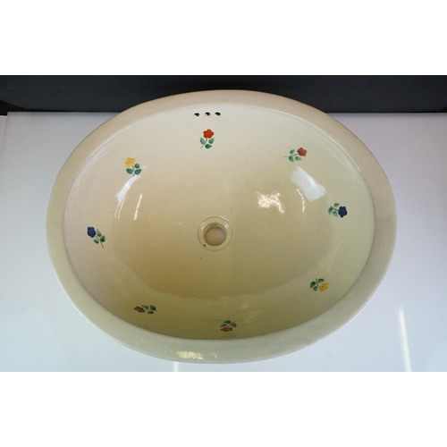 81 - Terracotta Mexican sink of oval form with floral decoration on a pale yellow ground, approx 50cm len... 