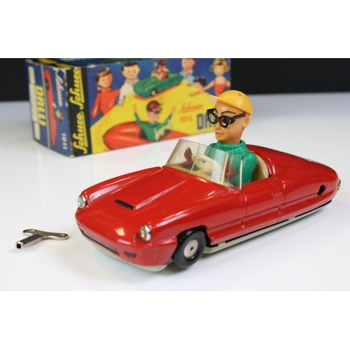 1266 - Boxed Dalli 1011 tin plate clockwork car in red, with driver in yellow cap and black glasses, minima... 