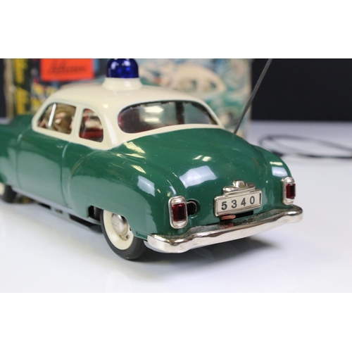 1292 - Schuco battery powered tin plate Alarm Police Car 5340 in green with cream roof and blue light, with... 