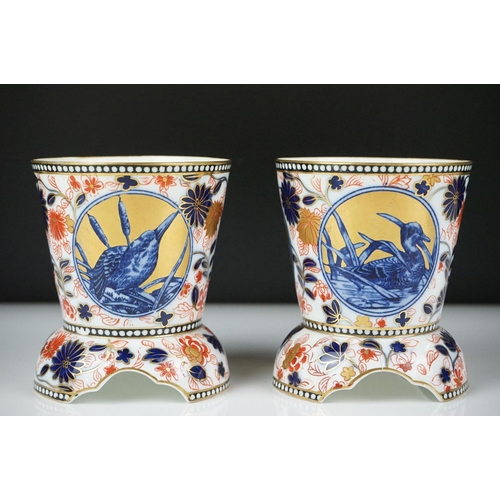 13 - Pair of Coalport Imari vases of tapering form, each raised on three supports, decorated with panels ... 