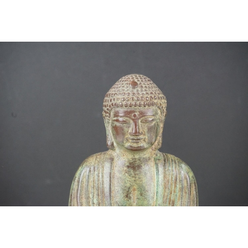 128 - Bronze figure of a Buddha seated in sattvasana clutching a bowl in both hands with a verdigris finis... 