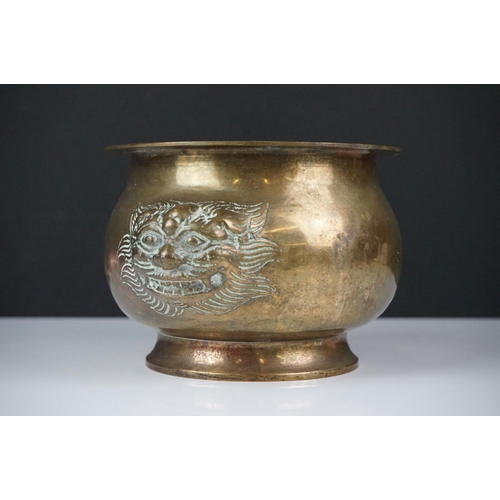 141 - Chinese brass censer with relief dragon mask decoration raised on a circular foot, approx 11cm high