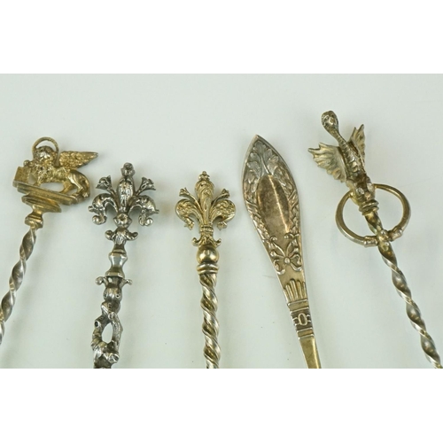 274 - A collection of five white metal teaspoons to include four gilt examples with ornate finials.