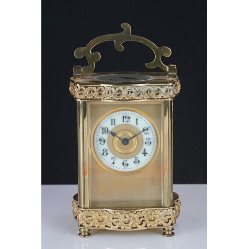 196 - An early 20th century brass cased carriage clock with bevelled glass panels and decorative dial, com... 