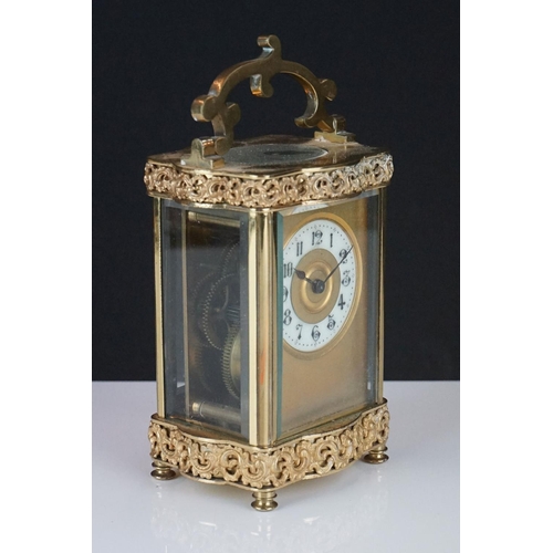 196 - An early 20th century brass cased carriage clock with bevelled glass panels and decorative dial, com... 