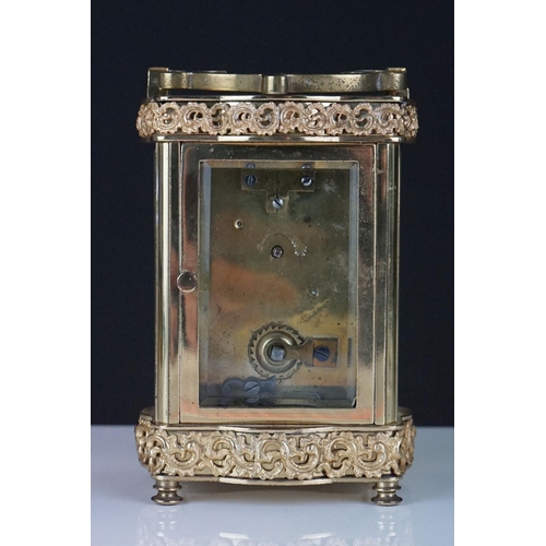 196 - An early 20th century brass cased carriage clock with bevelled glass panels and decorative dial, com... 