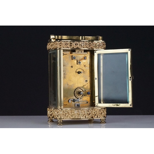 196 - An early 20th century brass cased carriage clock with bevelled glass panels and decorative dial, com... 