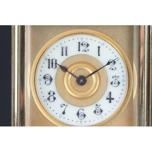 196 - An early 20th century brass cased carriage clock with bevelled glass panels and decorative dial, com... 