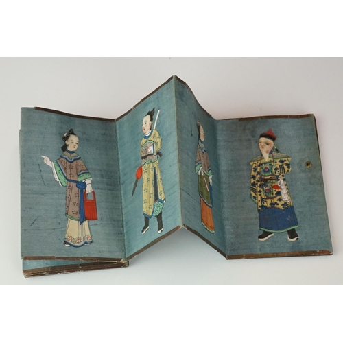 200 - A Chinese lacquer ware folding wallet of embroidered silk Chinese figures in traditional dress.