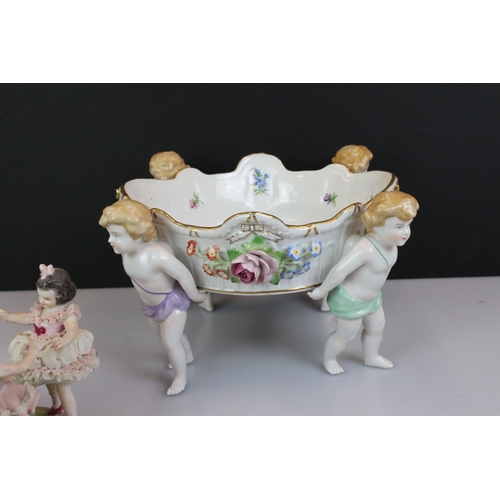 103 - Von Schierholz porcelain figural compote centre-piece raised on four feet, modelled as putti, with f... 