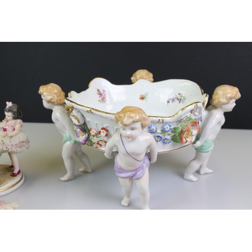 103 - Von Schierholz porcelain figural compote centre-piece raised on four feet, modelled as putti, with f... 